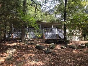 Inside Dardanelle city limits with city utilities but far enough out to have a real country feel; very natural setting with large rocks and trees, excellent condition, huge front deck for nature watching or sitting to read your book; large living area with rock wall containing fireplace, 3 bedrooms with split bedroom plan, master has tile walk in shower in bath, large vanity area, other two bedrooms arealso large and each has an inroom vanity and makeup area, full hall bath between those two bedrooms with tub/shower combo; laundry room is large and large pantry storage area; basement with inside stair access is great family area, game room, workshop at back of garage. Double garage attached but backdoor carport and covered entry gives you great access for unloading car; new roof