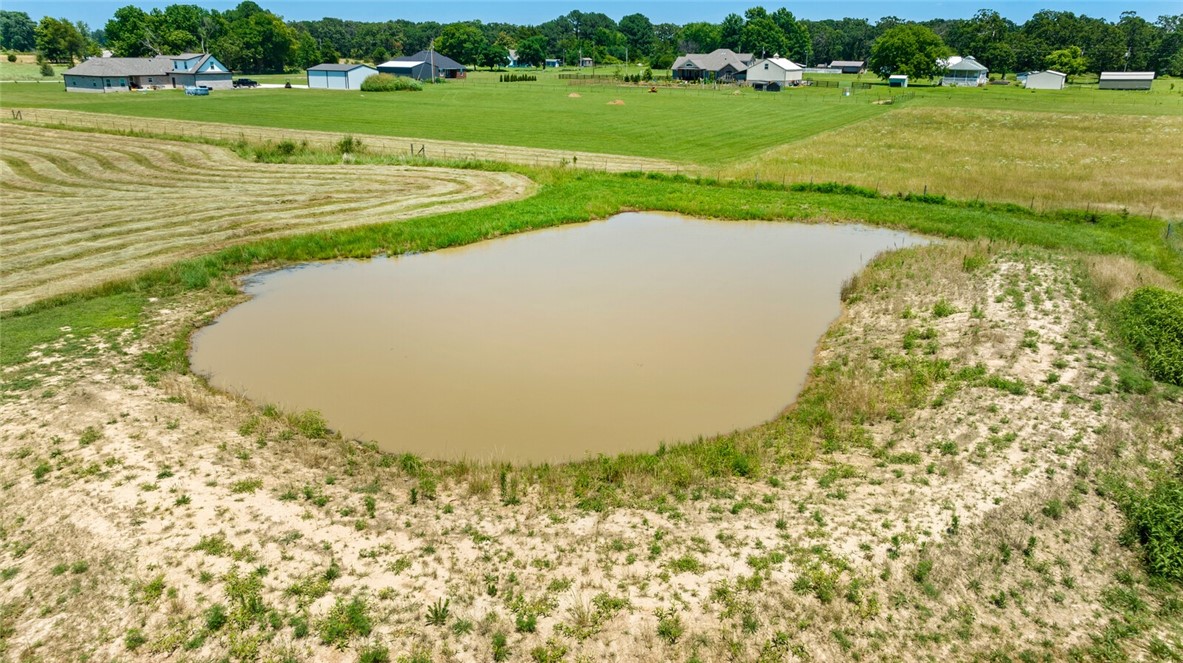 This is a 7 ac mol listing of raw land for a house or anything desired! Out of city limits with Gentry water at the road, currently used for a horse field, the end of the road with opportunity for someone who loves this area! Rare find! A new survey is completed. TWO ponds on the property with partial fencing/wire. No permanent structures on this subject property.