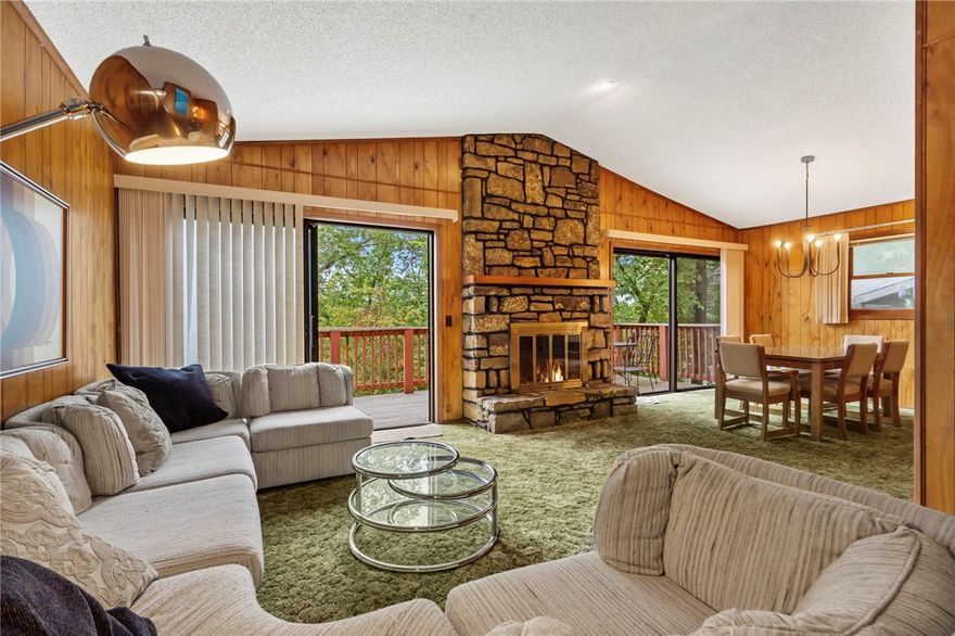 Step back in time with this rare lakefront retreat featuring its own private swim/boat dock! This 2-bed, 3-bath home embraces vintage charm with wood paneling, stone fireplace, and cozy cabin vibes throughout. Two spacious living areas and large decks overlooking the water create the perfect setting for gatherings or quiet escapes. Surrounded by mature trees and peaceful views, this property blends nostalgia with opportunity, whether you envision it as a full-time residence, vacation getaway, or investment. A true Bella Vista classic where comfort meets lakeside adventure.