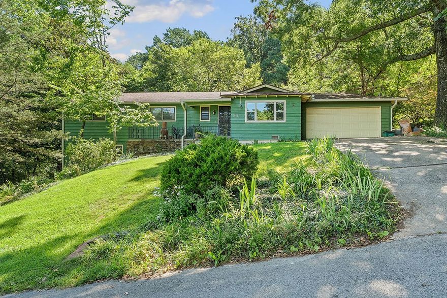 Big price drop in sought after Mount Sequoyah within walking distance to Root Elementary, but still private and peaceful with deer grazing and flowers blooming year-round in the large backyard. This lovely “Craftsman” family home sits on half-acre lot backing to a forest, but no worries--new gutters have leaf guards! On entry you are greeted by a big, warm, inviting living room with new Pella picture window that overlooks the forested hills below. Continue to the kitchen and dining room, each with new Pella sliding glass doors to back patio and yard. Main level features a primary bedroom with new carpet and an ensuite. Three more bedrooms and a bathroom on main level before heading downstairs for family game night in the giant great room with built-in fireplace, lots of windows and a flex space. Some new and fairly new carpet, hardwoods or new laminate floors cover the entire home. The entire interior and exterior are newly painted. Lots of storage in the crawlspace, indoor storage room, and two-car walk-in garage.