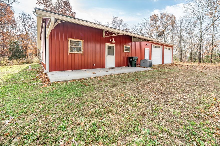 Experience the perfect blend of privacy, security, and modern comfort in this 2022 custom-built barndominium on 10+ acres filled with soaring oaks and beautiful winter views. Located in a gated setting just 7 miles from historic Eureka Springs, this low-maintenance retreat offers easy access to shopping, Table Rock Lake, Roaring River, and the White River. The open design features foam insulation, soaring ceilings, and an oversized garage with extra-tall doors—perfect for RVs or workshop space. The main level includes the primary suite along with a full and half bath. A unique guest room sits upstairs off the garage and overlooks the living area through an interior window(not included in main sq. ft. number). The fenced yard adds convenience for pets, and the in-garage tornado shelter provides peace of mind. Includes cell booster, outside island deck water/electric, leaf guards, 6" downspouts, water softener, added sound insulation, and insulated garage wall. A retreat surrounded by nature and beauty.