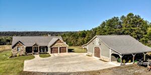 Drive in to your own peaceful paradise just minutes from town situated on approx 10+/- acres of private property! Step into excellence as you enter through your private gate and step into this 3 year old home. From the hand planed floors to reclaimed beams you will fall in love with all the details here. Enjoy your views of all the wildlife from your living area or sit out on the screened porch or open deck area complete with hot tub to relax in. Inside features amenities like hand planed flooring, reclaimed wood beams, jennair appliances, back up generator and tankless water heater. Large butlers pantry doubles as a safe room with concreter walls and ceiling. Outside shop features man cave/apt complete with full bath and cent ht/air. Shop features 14' roll up door and two carports!