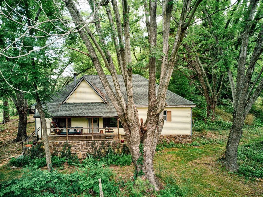 House needs some TLC being sold AS IS with no repairs. New roof in 2016, new hot water heater in 2018. Inspection is recommended. Value is in the land. 2 Parcels totaling 7.77 beautiful acres. The land features a small spring-fed pond native flowers, plants, and a peach tree. Lots of shade and tree coverage.