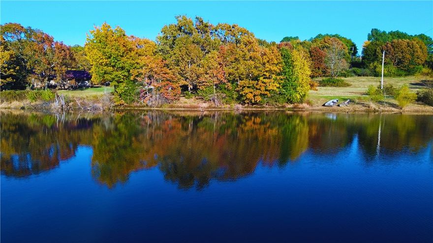 Secluded 13 acres less than 2 miles from I-49 & within 15 min of Fayetteville. Right on a paved road but totally secluded due to the beautiful mature trees surrounding this property. Pull down the wooded driveway to a house with a huge front porch and a 1200 sq ft shop. Large bonus room with outdoor access has many possibilities. Just outside the front door is a large pond covering over 2 acres thats loaded with fish. Have your own private mini farm or turn this into an income producer. This flat property sets up as a perfect place to add multiple small rental units with an outdoor focus. Fishing, camp fires, cookouts, nature trails. Super convenient location. It's getting really hard to find property with this kind of character so close to town. 10 min to Devils Den State Park. A lot could be done with this place.