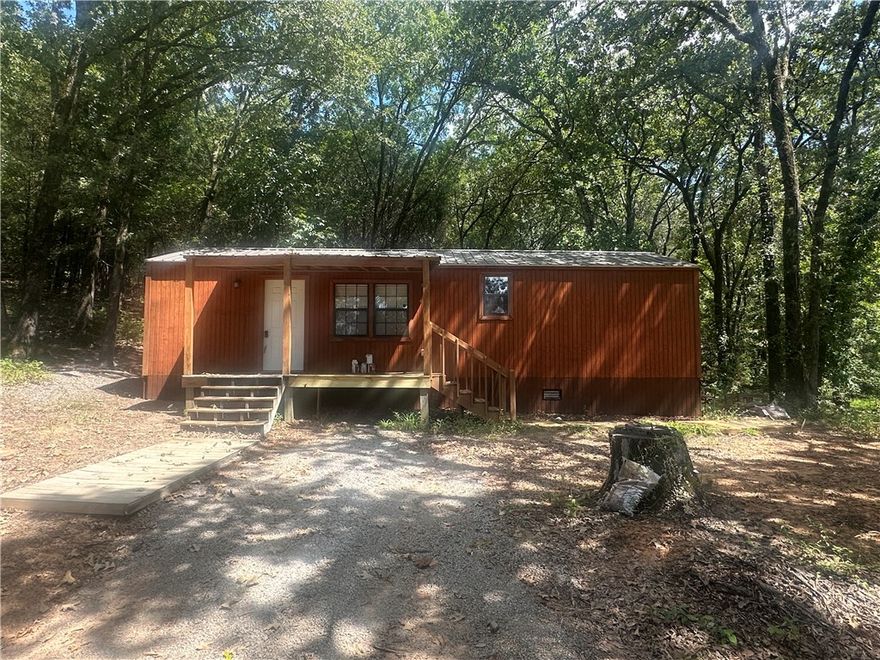 Secluded get away. Small home. Seconds from town but enjoy your privacy on 9.62 acres tucked away in the woods. 1 bed/1 bath, 672 HSF. LVP flooring throughout. SS appliances. Laundry hook ups in bathroom. Home has splitter unit & wood burning stove. Covered Deck that has been newly stained. Metal roofs. Tons of wildlife to enjoy, Home was appraised in 2024. Survey Available. County has agreed to take care of the road.