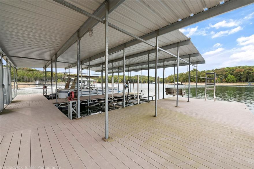 PRIVATE 2 SLIP DOCK WITH ONE LIFT AND SWIM DECK! Thirty-foot slips. Record size stripers have been caught in this treasured cove. Level, yes I said LEVEL easy walk to the water. This is the home you are dreaming of! Perfect for Momma on the inside, and the dock of Dad's dreams on the outside. Want to fish at night? Just turn on your trail lights for an easy, safe walk to the dock. Spacious airy comfortable inviting rooms; new flooring, paint, and decking.  Large Screened porch off master that has a commanding view of the cove. Beautiful land w/ beautiful homes on beautiful lake. Come get you some.