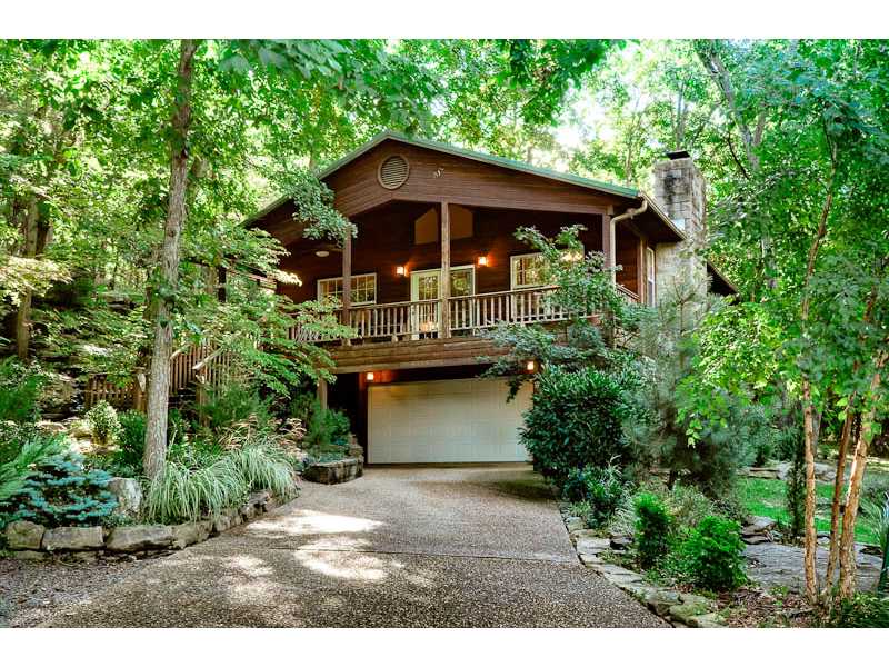 Rustic & Charming home nestled amongst the trees and bluffs on .46 acre lot. This custom built one owner home is ready for its new owners! Lots of natural lighting, open floor plan with vaulted ceilings, wood burning fireplace,wood floors throughout the main living area. Amenities: 2 Bedrooms 1-1/2 baths, eat-in kitchen with bar and dining area, oak cabinets,512 sq. ft. heated and cooled hobby room , shower & laundry room on lower level, covered wood deck, fabulous landscaping