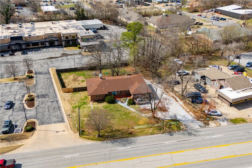 Unbeatable visibility directly on College Ave with 29,000 daily traffic count. The 3,447 sqft building, built in 1957, blends functional workspace with authentic mid century charm, featuring abundant natural light, original hardwood floors, and built ins throughout. The flexible layout could accommodate up to 10 private offices or studios, serve as a spacious headquarters for an owner occupant business, or be re-imagined into endless uses. Situated on a .47 acre lot, the property also includes a large fenced backyard, creating rare flexibility for park-like outdoor applications, future expansion, or additional parking. A unique opportunity for an investor or business owner to establish a highly visible Fayetteville presence in a character-filled space with room to grow.