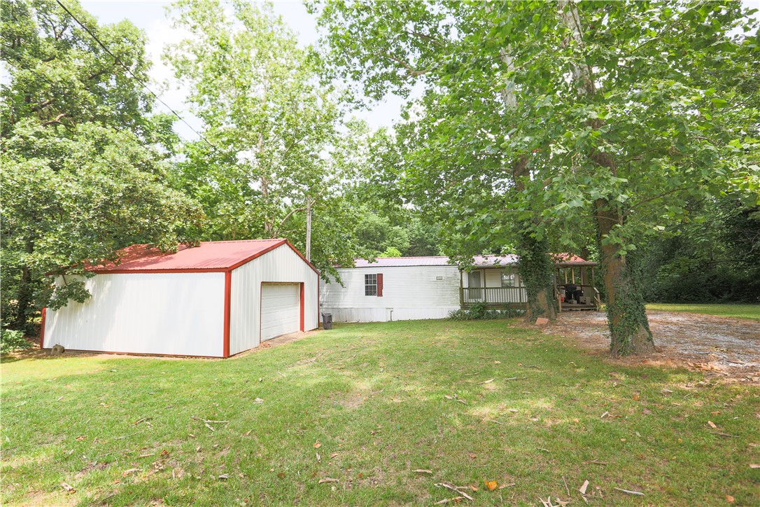 Don't miss this beautiful .4 acre treed lot with a fantastic 24x24 shop on a concrete slab and 220V electrical service. The property also has a 1999 Fleetwood single wide with a large covered porch that could be updated to make a nice little home. Just a half mile to town and the city park.