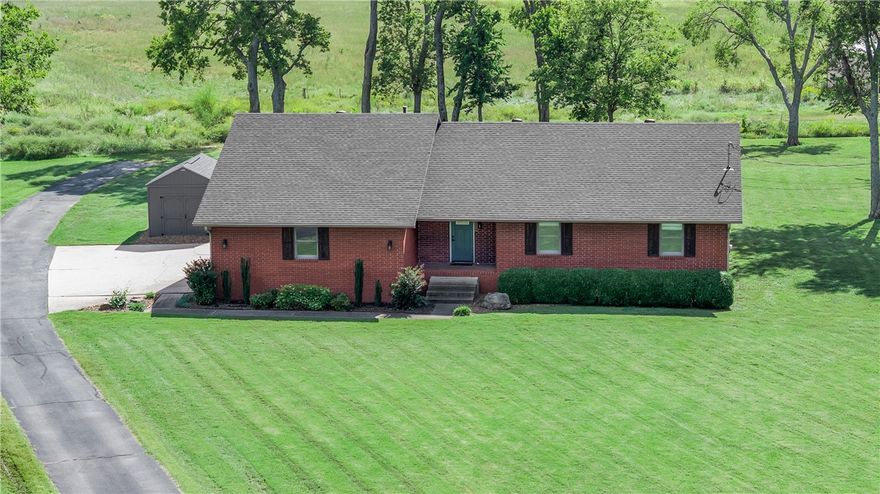 Beautifully updated home on 1.16 acres at the end of a cul-de-sac just off Highway 102, minutes from Downtown Bentonville, trails, and parks. Built in 1991, this 3 bedroom, 2.5 bath home blends comfort and convenience with a prime location. Hardwood floors flow through the main living areas, complemented by vaulted ceilings and natural light. The open living room connects to a spacious deck and fenced yard. The kitchen features granite counters and stainless appliances. The primary suite offers double closets and a walk-in shower. Updates include a new roof and HVAC in 2023. Extras include a 2-car oversized garage, storage shed, and 220-volt RV outlet. With its large lot, modern upgrades, and ideal location, this home is move-in ready. Approved borrowers will receive a closing cost credit of 1% of the loan amount up to $5,000 on their Closing Disclosure on their loan closing with Envoy Mortgage Branch NMLS #2659248 and Branch NMLS #2579798.