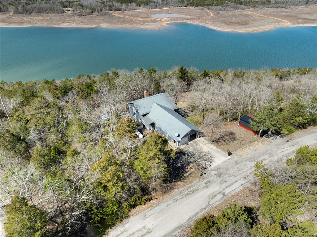 Stunning Home on Bull Shoals Lake with SIX lots!! This beautifully updated tri-level lakefront home is just minutes from downtown Lead Hill AR. The house and new 14x30 boat shed sit on 3 lots which all border the Corp, ensuring your lake view will not be blocked. The lower level has a large master suite, large family room with its own deck overlooking the lake, a rear patio off the BR, and a nice wood burning stove for those cozy nights. The main level offers a large living room with oversized windows overlooking the lake, updated kitchen, & dining room with its own screened in porch. The upper level offers the second full bath, and 2 large BR's, one with its own private deck overlooking the lake. When you're not out on the lake, the raised flower gardens, chicken coup, or outdoor grilling area with gazebo offers options for everyone in the family. The other 3 lots are directly across from the house, has a brand-new 24x24x12 shop with drive through capability, and its own driveway. Taxes & acreage are estimate.
