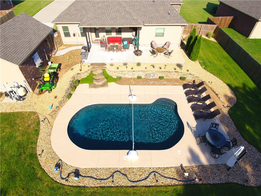 WOW! Get ready for summer! Beautiful gunite pool, peaceful backyard, extended covered & uncovered patios & upscale landscaping make this your oasis! The interior of the home matches the outside with upgraded fixtures, trim, granite & beautiful wood floors. Kitchen is superb with Electrolux stainless appliances & stainless farm sink. Security System. Surround Sound inside & out. Nest system. Garage just had an epoxy layer added. All on 1.03 acres! Nothing but trees outside your back fence. Come see how good life can get!