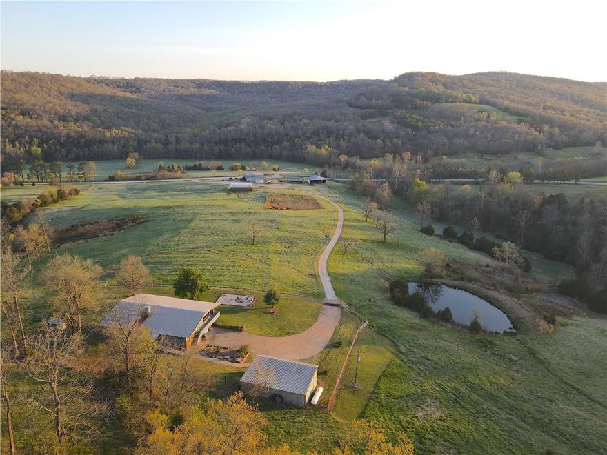 This one of a kind property has everything to offer. Upon entering through the gate, you are greeted with expansive pastures and stunning landscape. A metal shop sits at the front of the property featuring a 4 bed, 2.5 bath addition. Next to the metal building there is a fully operational cattle corral. As you pull up the driveway, you will notice the multiple out buildings and an equestrian barn equipped with stalls and tack room. The driveway continues up the gradual hillside to the main 3,789 Sq.Ft. home which has 6 beds, 4.5 baths. This home is 80% handicap accessible and has proven successful as a nightly rental. From the front porch you are able to enjoy breathtaking views of the surrounding landscape. With trails expanding to almost every corner of the property, you are able to make
your way through the forest with ease. A notable feature is a beautiful cave near the edge of one of the creeks. Following the creek up the mountain, you will come across a spring that is nothing short of impressive.