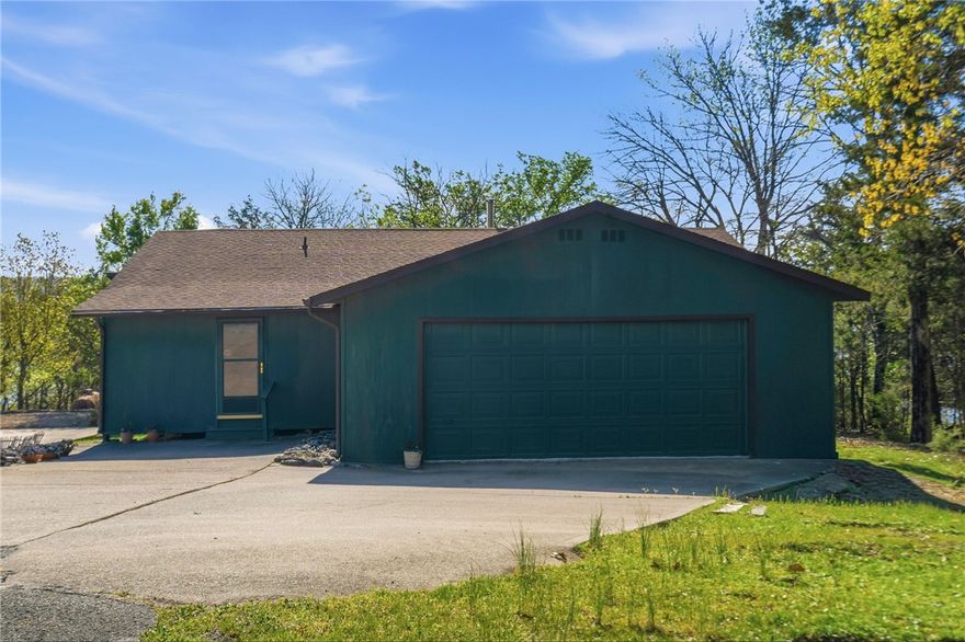Tucked atop a scenic ridge in Lost Bridge Village, this 3-bedroom, 2-bath home offers an opportunity to re--imagine a truly one-of-a-kind property. Set on a compact, yet desirable home site with incredible view potential, this 1,216 sq ft single-level ranch features a 2-car attached garage and a setting that invites creativity and vision. Originally constructed as a log cabin, the home has been uniquely expanded with a fully enclosed, framed exterior structure...creating a distinctive layered design, and a relaxing sun room that spans across the back of the house. This encapsulated layout offers a blank canvas for those looking to restore, renovate, or completely transform the space into something special. With selective tree clearing and the potential for a second-story addition, the property could capture sweeping, elevated lake views. This home is best suited for buyers with vision and an appreciation for its character, setting, and possibilities. Being sold as-is.