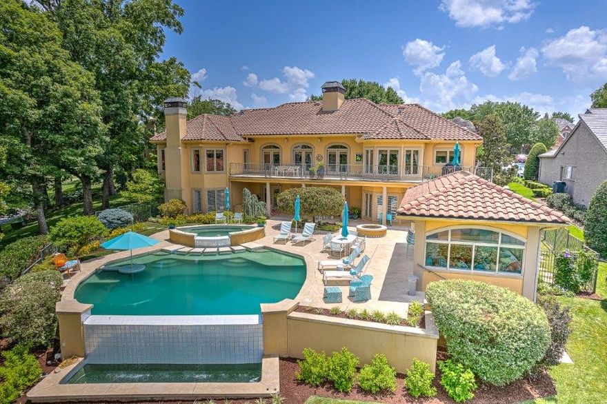 RESORT STYLE GOLF FRONT PINNACLE ESTATE OVERLOOKING THE 12TH, 14TH AND SIGNATURE 15TH ISLAND HOLES!  Custom designed and renovated to perfection, this spectacular setting boasts a backyard oasis with the private infinity pool making a seamless transition to the pond and golf course backdrop. Fully equipped poolside cabana boasts a kitchen, living, full bath and surround sound creating the ideal setting for entertaining and enjoying front row seats to the Walmart LPGA tournament!  Contemporary design elements with whimsical touches layered in fun colors and texture make the almost 6,000 sq ft interior a fun, vibrant and welcoming place to live, gather and entertain!  Main level hosts a formal living area w/ fireplace, office, formal dining, eat-in kitchen, hearth room, and a private master retreat w/ FP overlooking the golf course and featuring direct access to the main level balcony.  Full walk-out basement features living/media room w/ wet bar, bonus/living area w/ FP, 3 bedrooms, 3 baths, 2nd laundry area & more!