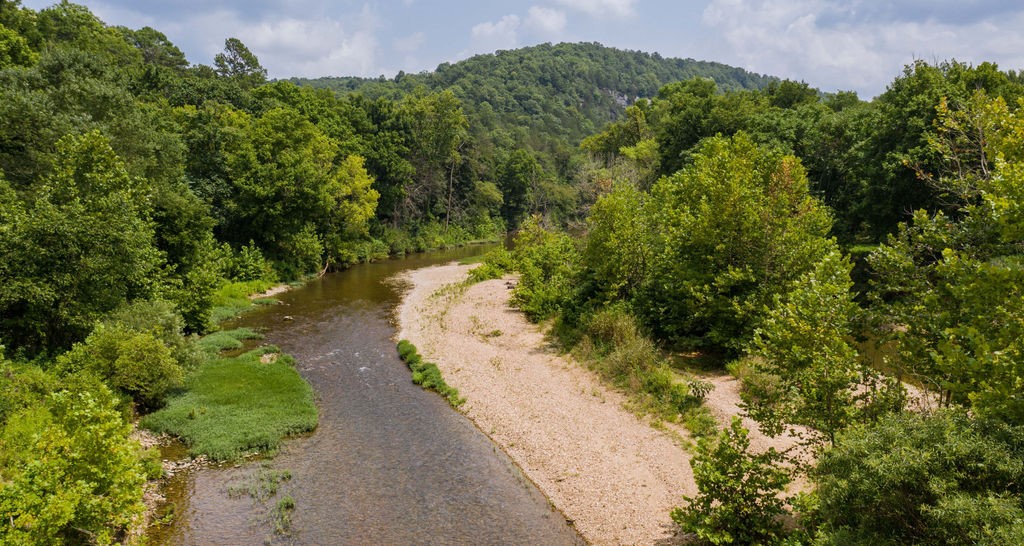 230 AC ON THE KINGS RIVER w/ 4500 ft of Kings River frontage on both sides of the River.
PRIME RIVER location 1/2 way between Marshall Ford and the Rock House access. Big Bluffs on both sides of the river and river access with River frontage on both sides. Spectacular views, many caves, walk down river frontage, fields, Island in the river, many springs, Miles of Mountain Bike or 4 wheeler trails already in place. Two of the Largest waterfalls on the Kings River which are a striking feature and breathtaking in their setting high above the river. Electric easement to property, SUPER REMOTE AND PRIVATE! Property is accessed thru Game and Fish Refuge on the west side of the River via cr 1200 and on the east side via cr 1715 and 1725. Hunting/ canoe club property. Approx. 182 ac on the east side of the river and 52 ac on the west side of the River. END OF THE ROAD Location .
Both sides of the river are feature packed. UNRESTRICTED LAND! See attached maps ***WILL CONSIDER DIVIDING