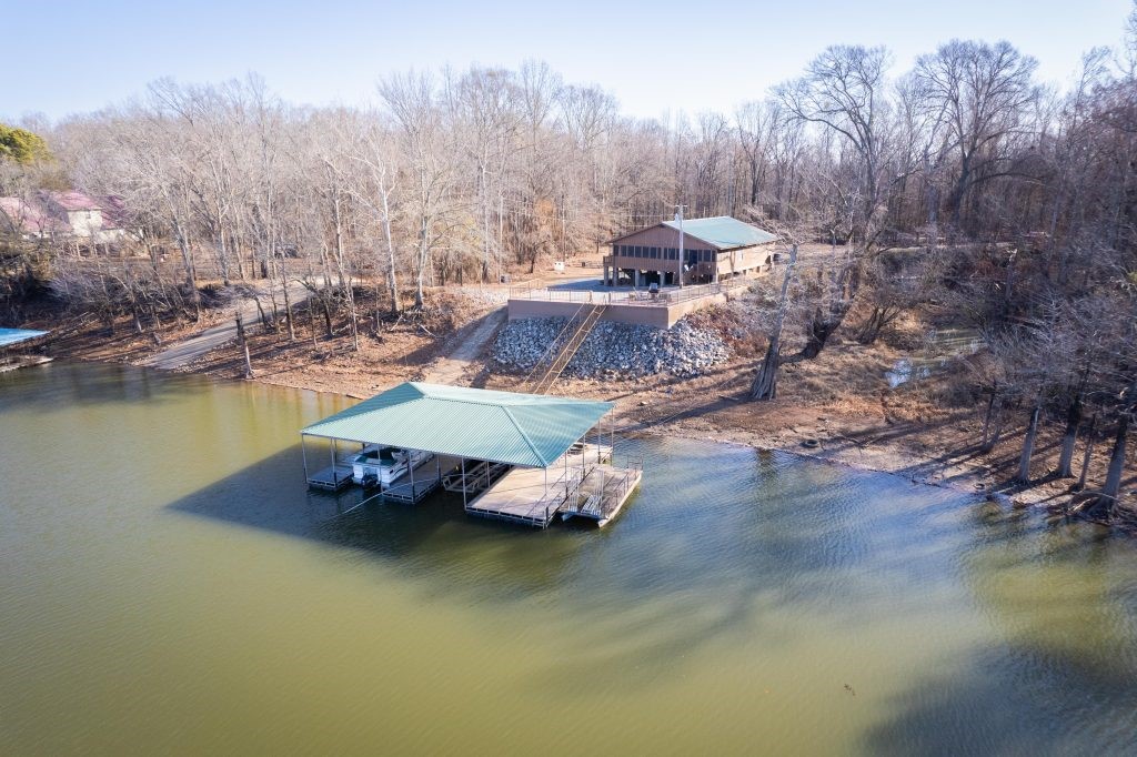 Big Deer, world class duck hunting, trophy fishing in multiple lakes, and total privacy on this oversized .68-acre lot on Maddox Bay with a rare large level yard. Your own concrete boat launch make Propert this one unique and hard to find. This retreat is set up perfectly and is turnkey with everything included in the purchase. All appliances, furniture, and the Party Barge pontoon and 4-wheeler pontoon with ramps to reach the Island of Paradise. The boat dock and walk ramp are new commercial grade and the rock work investment and improvements to the property are first class. 4 nice bedrooms with 2 full baths make it comfortable with the huge kitchen in the middle of the great room and dining room facing the bay.