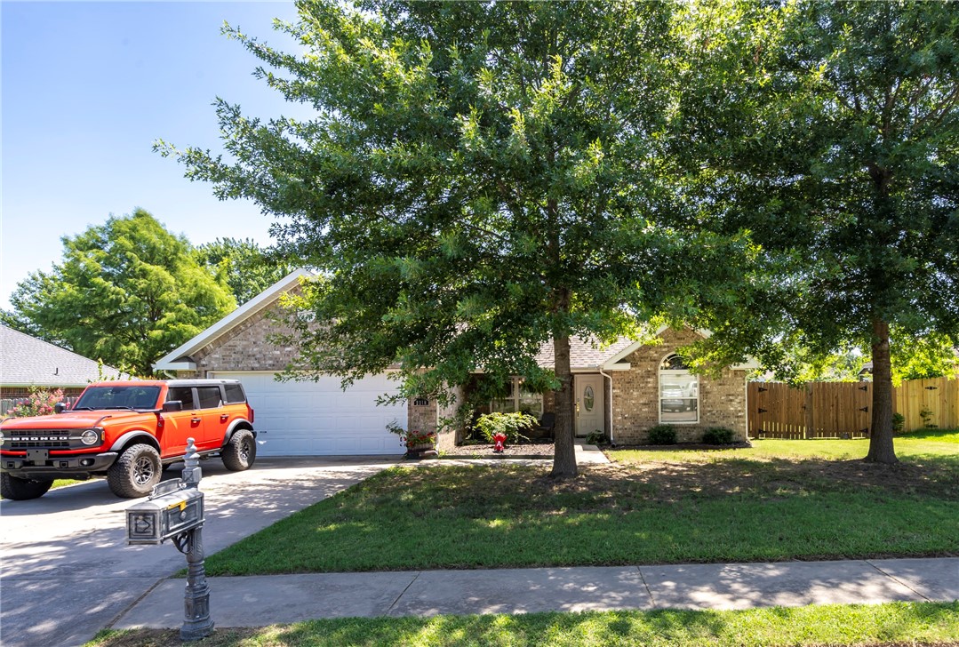 Welcome to this charming, well-maintained brick home in a desirable neighborhood. The inviting front exterior features mature trees and beautiful curb appeal. Step inside to find a bright and welcoming entryway that opens to a spacious living room with engineered wood flooring, crown molding, tall ceilings, and a cozy fireplace—perfect for relaxing or entertaining guests. The kitchen offers white cabinetry, stainless steel appliances, tile flooring, and ample counter space, flowing seamlessly into the dining area filled with natural light. Retreat to the generously sized primary suite featuring a tray ceiling, soft natural light, and direct access to a well-appointed ensuite. The large fenced backyard has plenty of green space and an oversized storage shed—ideal for hobbies, gardening, or storing outdoor equipment.