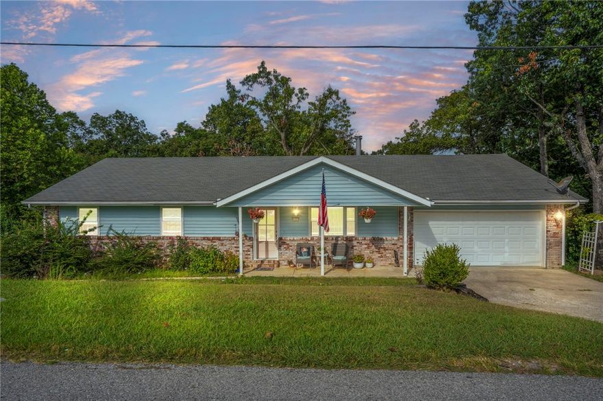 Discover Prairie Creek Lake-Living at its finest in this Mack-Grimes neighborhood charmer. Located off Scenic HWY 12, just 5 miles from Downtown Rogers and around the corner from Prairie Creek Marina, this home is nestled on .49 acres surrounded by stately oak trees. Perfect for those seeking a peaceful escape along with convenient access to everything, it's also within 30 minutes of Wal-mart headquarters. The main level features 3 bedrooms and an open concept, with the kitchen and walk-in pantry serving as the heart of the home. Enjoy bookshelves, wood flooring, and a wood-burning stove, perfect for cozy winter nights. The well-equipped kitchen boasts ample space, quartz countertops, a spacious laundry room, and updated appliances. Downstairs is ideal for teenagers, guests, or a mother-in-law suite that includes living space, a kitchenette, a bedroom and a full bath. In fact, this basement apartment is a standout feature. Come see! An additional .59-acre lot next door is available for sale for added privacy.