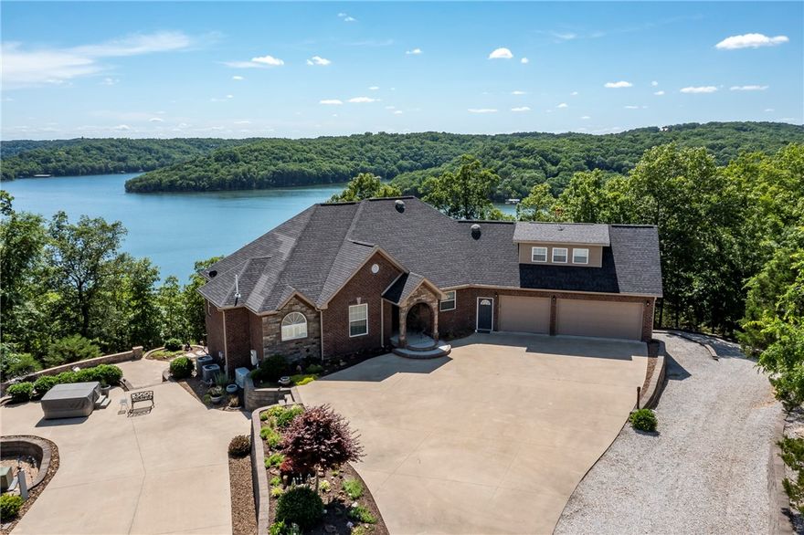OK, pack a lunch and come look at one of the nicest homes on gated 5+ acres at Beaver Lake.
Complete with TWO - 28' boat slips, just a short jaunt below the home. Home sets high for a panoramic view of Fords Creek & beyond. The 3400 SF shop can accommodate a Class A RV w/ room to spare for boat/trailer storage, work benches, cooled office space & half-bath. Outside the shop, you'll find a park-like setting w/ shuffleboard, RV hookup, fire-pits, & play areas. One-owner custom-built home in 2012 boasts: Open-concept design, Nine-foot ceilings, Wide hallways & doorways, Gargantuan-sized rooms, Heated floors, Media Room, Large windows, Generator. Numerous gathering areas outside the home, under multiple covered decks or by the hot tub on the concrete patio. The over-sized 3-car garage has plenty of storage. Home has option to be heated by the external Hardy wood-burning stove, two gas/electric heat pumps, or the two LP fireplaces. Buyer has option to purchase addt'l LF parcel w/ 2 boat slips directly from sellers.