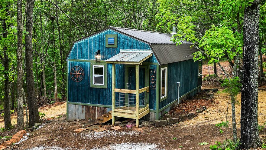 Charming tiny home retreat nestled in the scenic beauty of Winslow, Arkansas! Surrounded by huge trees and abundant natural light, this peaceful property offers postcard-worthy view and a serene setting perfect for relaxing or entertaining. Inside, you'll find high-end fixtures and a stunning oversized soaking tub with a view. The beautifully designed landscaping and custom stonework by a master stoneworker create exceptional curb appeal and outdoor charm. Additional features include two extra building sites- ideal for a shop or garage. Conveniently located near fuel, shopping, dining and approximately 23 minutes from the University of Arkansas. A rare opportunity to enjoy Ozark living in an idyllic setting!