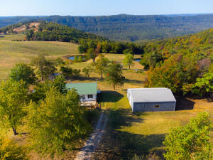 Breathtaking view of the Ozarks from this 3 br/2 ba home just minutes south of Jasper and less than 1 mile off Scenic Hwy 7. 1400 sq. ft living space (mobile home with 14'x50' addition), vinyl siding and metal roof. Great 10'x30' front deck and 8'x16' back deck. There's also a 30'x40' metal shop with concrete floor sitting on this fenced acre. Peach, Apple and Pear trees and small shed/coop. Minutes from Buffalo River, Arkansas Grand Canyon and Ozark National Forest.