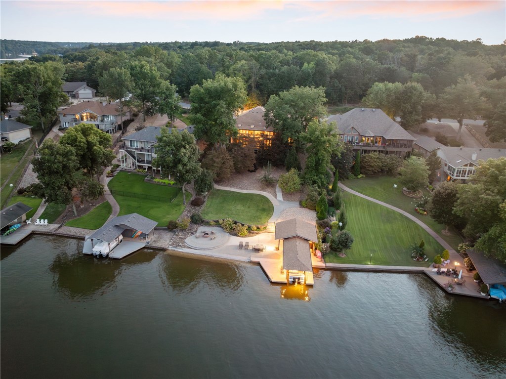 Nestled on the shores of Lake Loch Lomond, this remodeled lakefront home offers the perfect blend of luxury and comfort. Step inside to find a spacious, open-concept design featuring a large kitchen with sleek quartz countertops, newer appliances, and a seamless flow into the living room, all with stunning views of the lake. The main-floor primary suite is a true retreat offering peaceful lake views. The finished basement provides a second living area, two additional bedrooms, and a cozy bunk room, making it ideal for guests or family. Outside, you'll find an entertainer's dream with a private boat dock, a fire pit, and a relaxing lounge area. The outdoor kitchen comes complete with a built-in gas grill, while the beautifully landscaped yard includes fruit trees and a paved walking and cart path that leads directly to the lake. New HVAC system, water heater, and a new roof, ensures that everything is in top condition. This home truly offers everything you could dream of in a lakefront retreat.