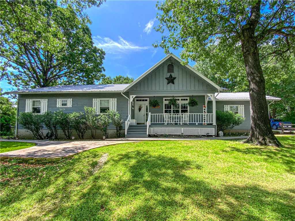 Looking for an idyllic homestead in the Ozark hills? This one checks all the boxes! Enjoy the large, fenced yard and garden areas, 6x8 greenhouse, Derksen 10x16 shed, chicken coop, mature fruit trees and berry garden, all on a flat, largely cleared 6.67 acres of useable land without covenants on a paved dead-end road. Updates and upgrades since 2021 are too numerous to mention but include new HVAC and HW on demand systems, whole house generator and surge protection, water softener, gas log peninsula fireplace with rock surround, LED lighting, premium granite kitchen countertops, major appliances, bathroom fixtures, and w/w carpeting, just to name a few. The craftsmanās 24x30 shop with ½ bath is every manās dream with new roof, lighting, toilet and water heater, mini-split for heat and a/c and a woodstove for backup heat. Rest easy knowing the generator has a new separate 1,000-gal propane tank. There is even a new 6x8 in-ground storm shelter. Take the virtual tour to see this gem. Call today! This one wonāt last!