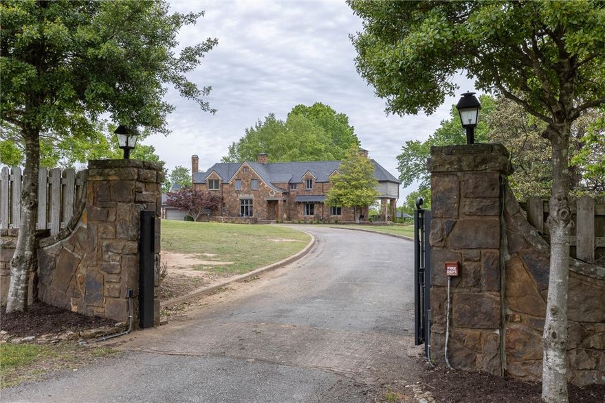 Private gated estate with amazing views near Fayetteville Country Club. This timeless beauty offers a main house (5,626 sf), guest house (1,323 sf), pool house (323sf), detached carport, and an in-ground pool situated on 2.67 acres of land. The main house has 5 bedrooms, 4 full bathrooms, 1 half bath, oversized living room, eat in kitchen w/ hearth room, dining room, butler’s pantry, library, coffee bar, utility room, and a bonus room with an upper level composite deck overlooking the grounds. Guest house has 1 bedroom, 2 full bathrooms, an office, eat in kitchen, and a living room. Other amenities include synthetic slate roof, newer HVAC systems, yard irrigation, circular drive, in-ground chlorinated pool, multiple outdoor flagstone patios for entertaining, copper guttering, wool carpeting, and original hardwood floors. The home offers old world charm and unique custom features that boast a really comfortable feel.