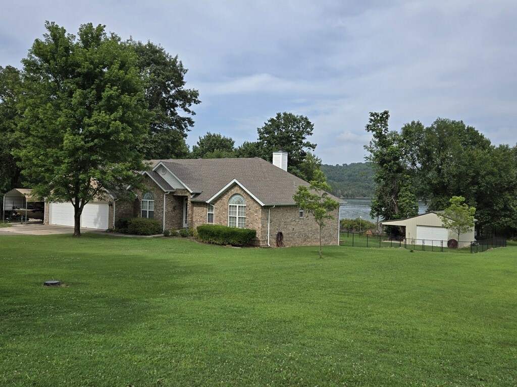 Discover a one-of-a-kind opportunity with this exceptional 2,740 sq ft lake home, ideally situated on a rare flat lot with direct water access and scenic views. All living space is on a single level, including a newer addition that offers panoramic lake and nature views.
The property backs to a serene buffer owned by the U.S. Army Corps of Engineers, ensuring lasting privacy and unspoiled surroundings. A 600 sq ft turnkey shop features electric, water, spray foam insulation, and a wood-burning fireplace—perfect for hobbies or extra storage.
Set in a peaceful lakefront neighborhood with community boat access, this property blends tranquility and convenience—just 15 minutes to both Rogers and Fayetteville. Whether as a full-time home or weekend escape, this is your chance to own a true unicorn—lakefront, flat land, and packed with value.