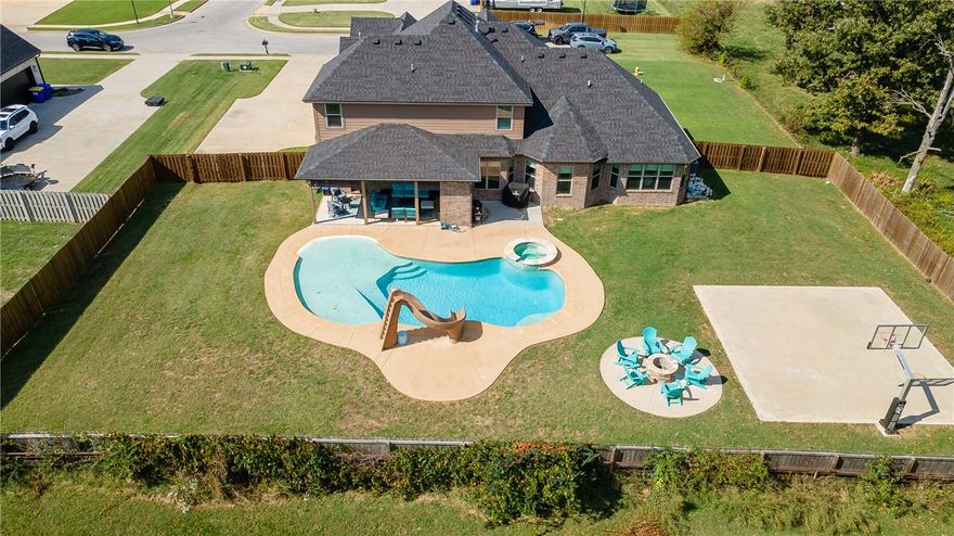 Set on a scenic half-acre corner lot in Elm Springs, this 5-bedroom, 4.5-bath home offers exceptional space, comfort, and style. Outdoor living shines with a sparkling pool, half basketball court, and covered patio ideal for entertaining. Inside, the thoughtful floor plan includes three ensuite bedrooms, two on the main level including the spacious primary suite with an oversized walk-in closet, plus one upstairs, along with two additional bedrooms connected by a double bath. A dedicated office, formal dining room, and generous bonus room provide flexibility for work and play. The 3-car garage adds convenience and ample storage. Blending elegance with function, this home sits in a peaceful neighborhood with quick access to everything Northwest Arkansas has to offer.