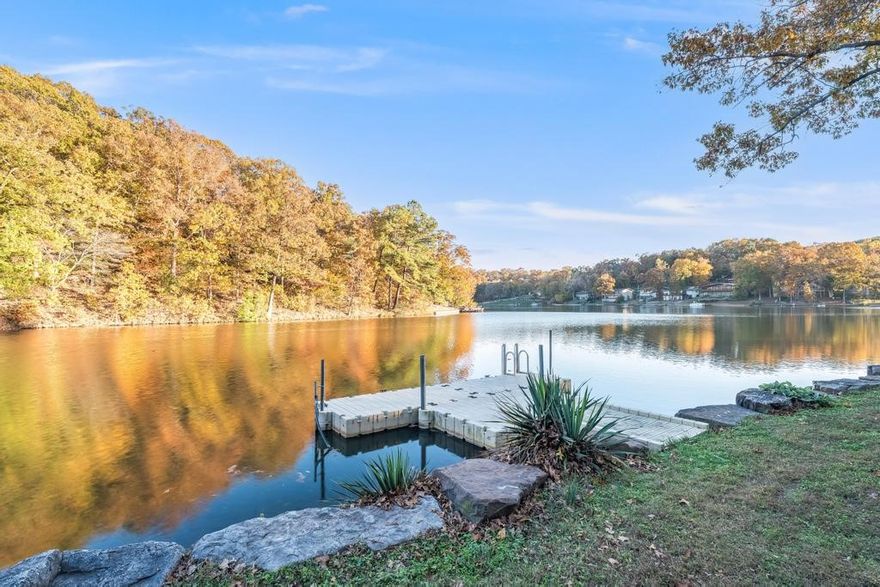 Properties like this don't come along often! A large gently sloping "walkable" 0.73-acre lot with 166ft of lake front, centrally located on beautiful Lake Avalon! Plus, a NEW ROOF, gutters & skylight installed Oct 2025! Natural light & wood floors flow throughout the house. Large deck (half screened in) is accessible from dining room & primary bedroom. Kitchen has granite counters, stainless appliances, pantry & tons of cabinet & counter space. Living room has large windows with views of the front yard & stone gas fireplace. All 3 bedrooms & laundry room are upstairs. Downstairs is a bonus room with walk-out access to a covered deck & the backyard. Exterior stairs connect the upper & lower decks. Enjoy everything that Bella Vista has to offer - located close to the Bella Vista Country Club Golf Course, Tanyard Creek, Bella Vista Waterfall & the Little Sugar trail system. Easy access to the water, fire pit & swim deck that conveys. New stone sea wall recently installed. New furnace 2023. Shed & propane tank convey.