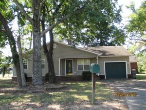 Brick and vinyl 3 bedroom 2 bath home on a corner lot with 1-car garage, porch, patio, and fenced back yard.