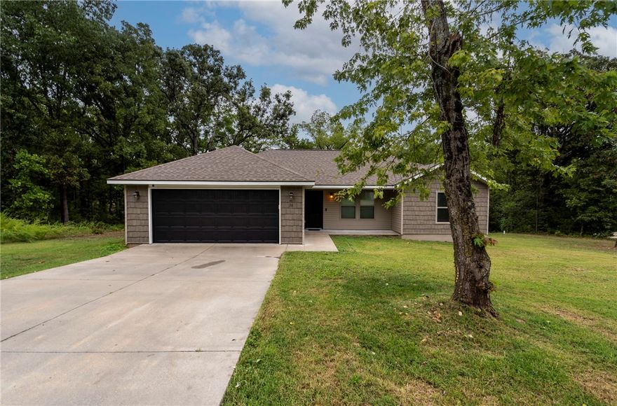 Welcome to this charming 3 Bed 2 Bath all electric home nestled among the trees on a large lot in Bella Vista, AR! Enjoy the peace, privacy & nature from your beautiful covered deck & privacy fenced backyard or your large covered front porch. Conveniently located just minutes from trails, lakes, golf courses & all Bella Vista amenities. Built in 2019, this home features a split bedroom floor plan with an open layout, durable lvp flooring through out, an electric log fireplace for a cozy atmosphere, adorable barn door pantry, blinds, ring doorbell, walk-in closet in primary & much more. Has new interior paint, garbage disposal & kitchen faucet. Refrigerator, washer & dryer all convey with the home. This property is move in ready & offers the perfect balance of style, comfort & outdoor living.