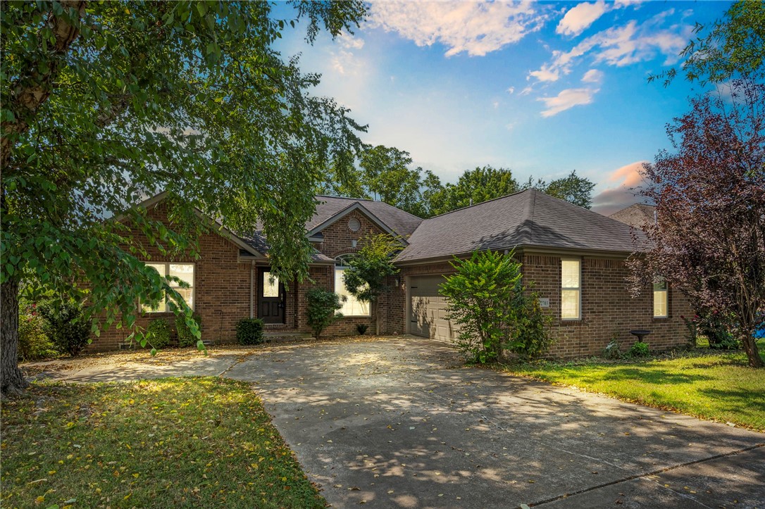 Welcome to this charming 3-bedroom, 2-bathroom home nestled in the heart of Bentonville, AR. This inviting property features a spacious open-concept living area with a cozy fireplace, perfect for relaxation. The well-appointed kitchen boasts ample cabinetry, stainless steel appliances, and a convenient breakfast bar. The primary bedroom offers a generous space with a ceiling fan, while the attached bathroom includes a relaxing jetted tub and dual vanities. Enjoy the serene backyard with a deck, ideal for outdoor gatherings, and a well-maintained lawn. Located just minutes from Walmart headquarters, Applegate Trailhead, Coler Creek and Gatway Park Subdivisions. With its appealing design and great neighborhood, this home is a must-see!