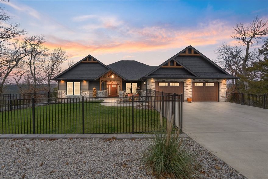 Experience this custom-built mountain craftsman lodge with jaw-dropping view of Holiday Island & Table Rock Lake. This one-of-a-kind home offers an open, split floor plan with 2 bedrooms, 2 bathrooms, & a versatile flex space off the foyer—ideal as an office, arts/crafts room, or library. The chef's kitchen features quartzite countertops, a 36" gas cooktop, wine cooler, walk-in pantry, & custom cabinetry. An expansive island & open-concept design flow seamlessly into the living room perfect for entertaining. Wood-tone luxury vinyl plank flooring, plantation shutters, & a gas fire place with a live-edge walnut mantel enhance the inviting atmosphere. Enjoy unparalleled views from the all-season sunroom, screened deck with pull-down shades, or open deck for stunning sunsets. Other highlights include spa like ensuite bathrooms, a 3-car garage, Elfa closet systems, a 24k whole-house generator, a fenced yard with irrigation, plus an approximately 2500 sq ft unfinished lower level ready for your personal touches.