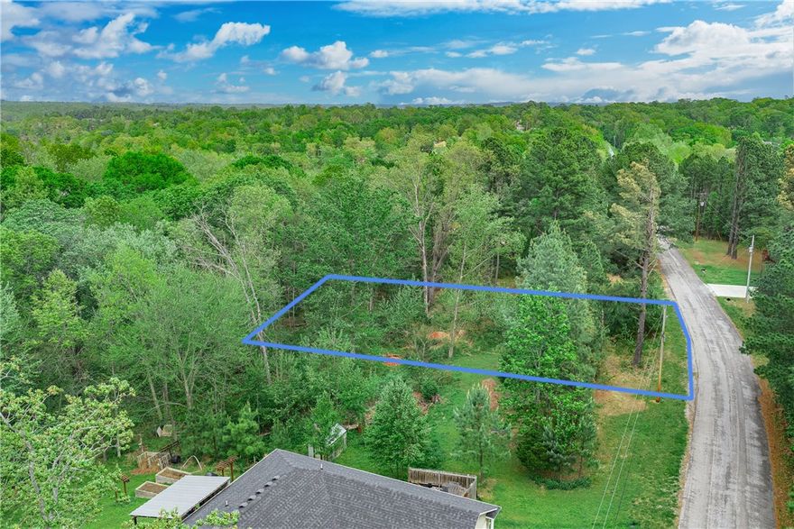 Nestled in Bella Vista's established Stirling subdivision, this beautifully wooded 0.28-acre lot is your opportunity to build in one of NW Arkansas's most sought-after communities. With 84 feet of street frontage and a gently sloping, tree-covered setting, you'll enjoy natural privacy and genuine Ozark character. Public water is already on site, electric is at the street, and the property sits outside the flood zone — making development refreshingly straightforward. Annual taxes are an incredible $49! As a Bella Vista POA member, you'll have immediate access to 7 championship golf courses, 7 pristine lakes, tennis courts, fitness centers, pools, and miles of world-class hiking and mountain biking trails — all just minutes from your doorstep. This is resort-style living at an unbeatable value. Priced at $26,000, don't wait to make Bella Vista home!