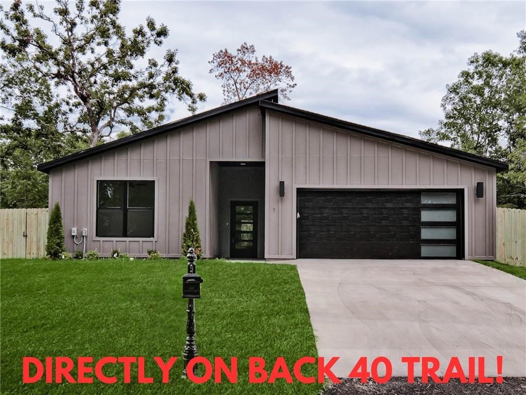 MOVE-IN READY modern new construction home directly on the Back 40 Trail! Completely flat .34-acre corner lot. Wood privacy fence! This stunning residence features a waterfall kitchen island, stainless steel appliances including gas range, 3 cm countertops, a walk-in pantry, custom cabinets, & high-end finishes throughout. The inviting living space boasts 10-foot ceilings and a beautiful fireplace, while the oversized custom tile shower adds a touch of luxury to the primary bath. Step outside to the large covered porch—perfect for relaxation and entertaining. Close to Lake Ann. Bentonville schools!