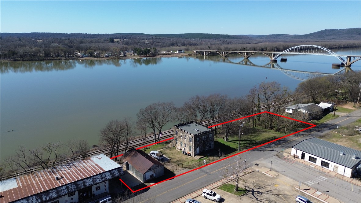 This renovated 1914 built jailhouse in Ozark, AR on the Arkansas River seamlessly blends its past with the comforts of modern living.
Key Features:
⢠Retaining original architectural elements, such as unique keystones above the entry, iron doors, 14" concrete (that contributes to sound and weather proofing), exposed brick and limestone walls, this home provides a tangible connection to the past.
⢠The property has undergone a complete transformation such as plumbing, gourmet kitchen and central heat & air.
⢠The former cell blocks have been repurposed into spacious bdrms and living areas, offering a truly distinctive floor plan and maintained etchings of names from prisoners.
⢠Incredible views of the Arkansas River, rooftop patio, metal shop and spacious adjacent buildable lots.
Close to everything and incredible views on the river make this the most unique Jail/home you may ever have the oppty to own! Call for a private showing for qualified buyers.