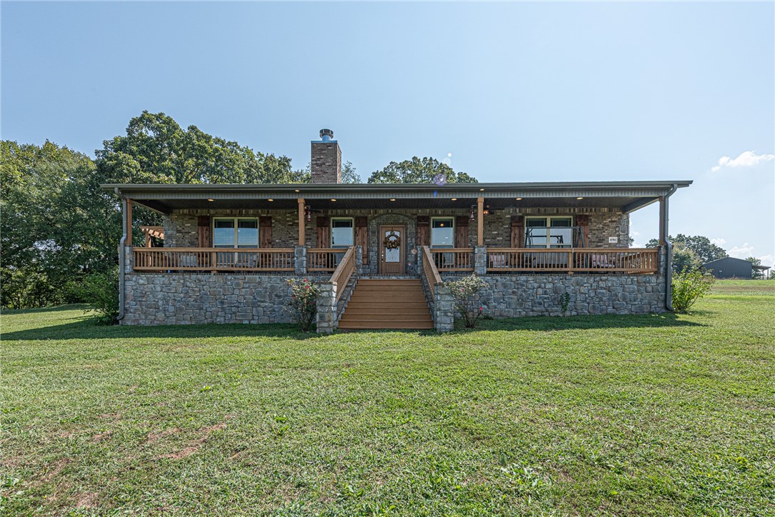 Welcome home! Brick & stone 3 bd, 2 bath home w/ 1,940 sq ft, built in 2017, situated on 12.91± AC. Located <8 miles from the University of Arkansas, downtown Fayetteville, Prairie Grove, & Farmington. Covered front porch spans width w/ mountain & countryside views. Open concept living w/ vaulted ceiling, wood flooring & statement FP w/ stone, brick & wood accents. Kitchen offers stained cabinetry, tile backsplash, granite counters, stainless steel appliances, walk-in pantry, & curved counter-height peninsula. Primary suite feat: 2-way fireplace, private patio access, & ensuite w/ dual sink vanity, tiled dual-head shower, & walk-in closet connecting to laundry w/ utility sink. Two add'l bedrms & full bath! Exterior amenities: 30x30 shop w/ elec + attached 600 sqft 1 bdrm/1 bath apt w/ kitchen & living. 2 septic systems (main home & apt), RV pad w/ 50-amp plug, water supply, & dump station. Existing pecan trees & mostly cleared acreage w/ creek provide options for hobby farm or recreation. Don’t miss out! Act now!