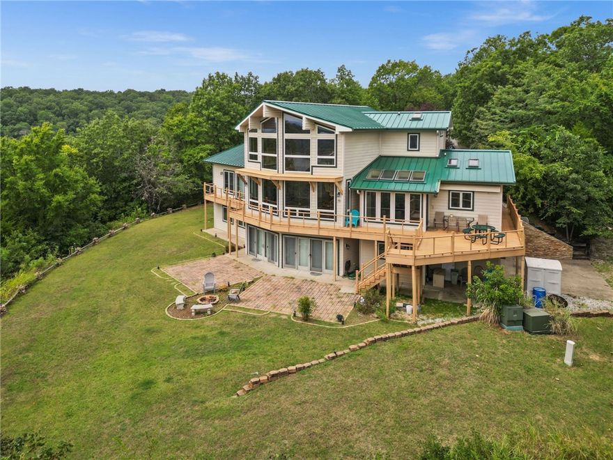 Private 11.08 acre Beaver Lake retreat with expansive lake views that includes a 4,440 sq ft main home and 644 sq ft guest house. This 3 bedroom custom Stitt Energy home showcases sweeping lake views from nearly every room.  Designed for both relaxation and entertaining, the home features spacious living areas, large windows and seamless indoor-outdoor flow to expansive decks overlooking Beaver Lake.  A charming 644 sq ft guest house with a garage provides the ideal space for visitors, extended family or a private office.  Whether you're enjoying the quiet of your private acreage, taking in breathtaking sunsets, or hosting gatherings, this property offers a rare opportunity to own a true lakeview sanctuary.  Conveniently located 3.5 miles from Lost Bridge Marina where the 10'x24' leased slip with a boat lift can transfer to a new owner and only 0.4 miles to Beaver Lake Sailboat Club.  Extra amenities include a whole house generator, a detached 10' x 12' storage building, a fire pit, and ample parking.