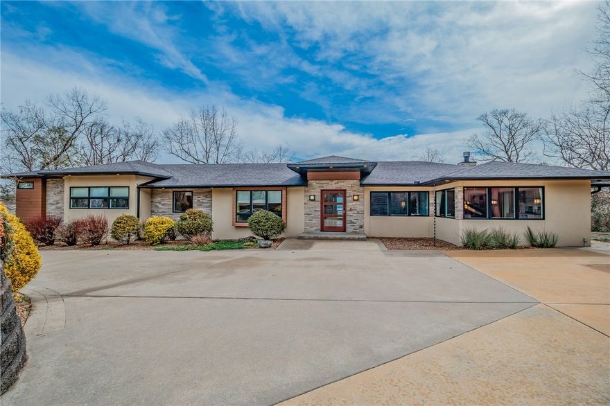 Lakefront Mid-Century Modern home with incredible Beaver Lake views offered fully furnished & move-in ready. Perched on a private waterfront lot, this architecturally striking residence features modern lines, expansive windows and an open layout designed to capture the water from multiple vantage points. Chef’s kitchen with waterfall island and separate scullery for additional prep and storage. The main level offers 3 bedrooms including a spacious primary suite with spa-like bath and large walk-in closet. Flexible living spaces include a bunk room, game room, office, and a 4th bedroom currently used as a custom hobby/music room (seller willing to add closet). Outdoor living includes multiple decks, patios and screened porches overlooking the lake. Private tram provides easy access to the dock with oversized slip, swim deck and lift located in a protected cove. Detached 2-car garage. Close to state parks and mountain biking trails.