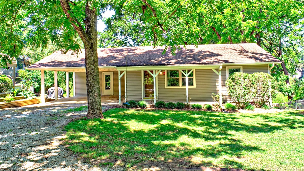 Peaceful lake community convenient to Fayetteville or Springdale! Beautifully maintained 3BR/2BA home with covered front porch, spacious back deck, and partial lake views. Just 1/4 mile to community lake access and boat ramp. Main level features a living room, kitchen, 2BRs, full bath, laundry/mudroom, and office. Walk-out basement offers a 2nd living area, bonus room, BR, and full bath. Includes 2 carports and detached shed. Ideal for full-time living or a weekend retreat!
