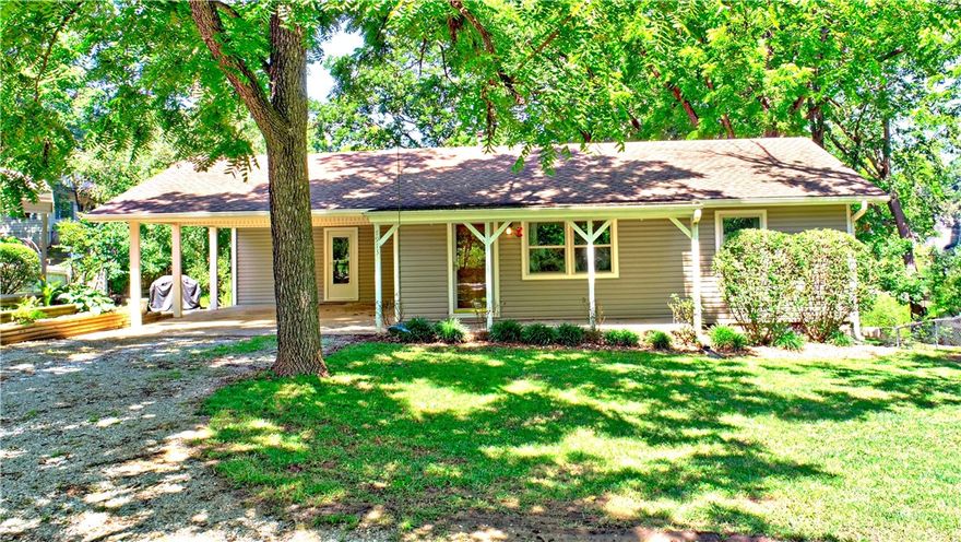 Move-in ready 3BR/2BA home in a peaceful lake community, conveniently located near Fayetteville and Springdale. The covered front porch, spacious back deck, and partial lake views create a welcoming setting, while fresh interior paint gives the home an updated feel. Just 1/4 mile from community lake access and a boat ramp, it’s perfect for enjoying time on the water. The main level features a living room, kitchen, two bedrooms, a full bath, a laundry/mudroom, and an office with built-in desk and cabinetry. The lower level, with exterior access, includes a second living area, a bonus room, a bedroom, a full bath, and an additional room that could serve as a 4th bedroom or flexible space to fit your needs. Additional property highlights include two carports, a 12x16 tool shed with power and lights, and an 11x26 boat storage carport with power and lights. This home is perfect for full-time living or as a weekend retreat. Seller is ready to review offers & can accommodate a quick close!