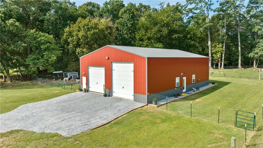 Escape to 23.15 acres of peaceful countryside just west of XNA! This farm property offers a 2,400 sq. ft. shop house. Approximately 1,200 sq. ft. has been converted to living space, including a kitchen with granite countertops and a large island, 1 full bathroom, two additional rooms currently used as bedrooms, a closet space, and attic access for extra storage. With electric, water, and sewer connections already in place, it's ready for you to make it your own. You will find multiple building locations throughout the property to build your own personal estate home. A 1/4-mile driveway ensures maximum privacy, while a wet-weather creek adds natural beauty. Located minutes from a new restaurant, brewery, food truck park, and the rapidly expanding amenities of Highfill. This property is surrounded by large estates, offering both seclusion and increasing value. Live here while building your dream home or convert this space into an ideal in-law suite – the possibilities are endless!
