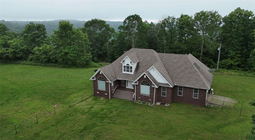 Looking for an Ozark mountaintop retreat? This beautifully remodeled brick home (2023) offers 5 bedrooms and 3 baths with modern upgrades throughout, including new flooring, paint, cabinets, doors, and lighting. A new roof was added in 2021, HVAC utilizes two geothermal systems and an upper-level mini split. The spacious main level features a stunning great room, formal dining area, and a primary suite with large windows, a private bath, and walk-in closet. The stylish kitchen includes a dine-in area perfect for gatherings. Enjoy relaxing in the sunroom or step out onto the expansive curved deck overlooking the mountains. The property also includes rural water service, and fiber internet access. There is a well that could be reactivated with a new pump for irrigation. Lots of room to build a shop or plant a garden. Backing up to protected Ozark National Forest, this home offers privacy, beauty, and modern comfort in a serene setting.