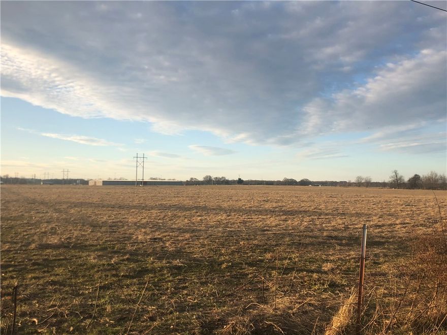 Over 25 acres level, open land with development potential. Directly across the street from new Bentonville Public Schools property and surrounded on two sides by the Benton County Fairgrounds. Would be great site for multi-family development. 25.6 acres MOL as shown in photos to be surveyed from total acreage. Buyer to verify all utilities.