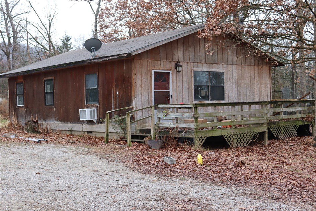 Little cabin with large living-dining-kitchen area. Land has a little spring, some nice trees and sloped a little after nice yard. Home needs work and will not qualify for specialty loans or RD. Being sold as is. Lots of potential for a home and three acres out in the country-rural water.