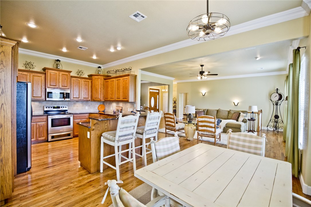 Warranty Included! Bentonville School District. Pristine custom home with gorgeous 3/4 inch hardwood floors, 10 Foot ceilings throughout the main level, extensive crown molding and many updated light fixtures. High quality cabinetry with granite countertops. Lower level Family Room could easily be made into a 4th Bedroom. Private low traffic street, lawn irrigation, scenic views from back deck and fast easy access to HWY 71. Oversized 2 car garage with extra space for storage or workbench. Private low traffic street. Hard to find one this clean-----Move in ready.