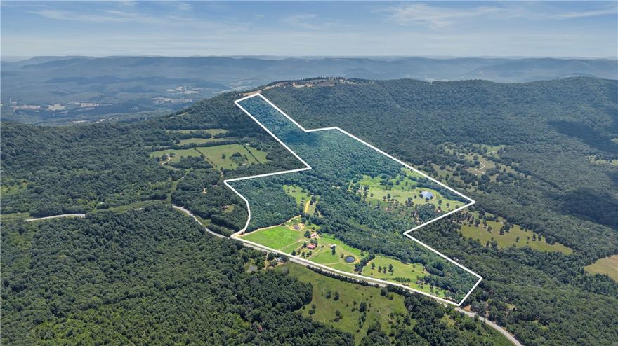 This 150.33-acre property in Newton County offers exceptional development potential with some of the most breathtaking Ozark views in the region. Featuring a year-round spring that flows directly from the mountainside, multiple ponds, and a blend of open pasture and wooded terrain, this tract is ideally suited for a cabin resort, short-term rental retreat, or recreational development. A 45-acre wooded section accessible from CR 4810 includes utilities, rural water, and prime wildlife habitat—perfect for expanding with cabins or hunting leases. The ridgetop offers unmatched “top-of-the-world” building sites with panoramic views, including Red Rock. With electric, septic, and phone already in place, the property is ready for immediate transformation. Secondary features include a 1,960 sq ft two-level home and three additional structures with guest house potential. Owner financing available with 20% down and flexible terms. Rare chance to build, invest, and create something special in the Ozarks.